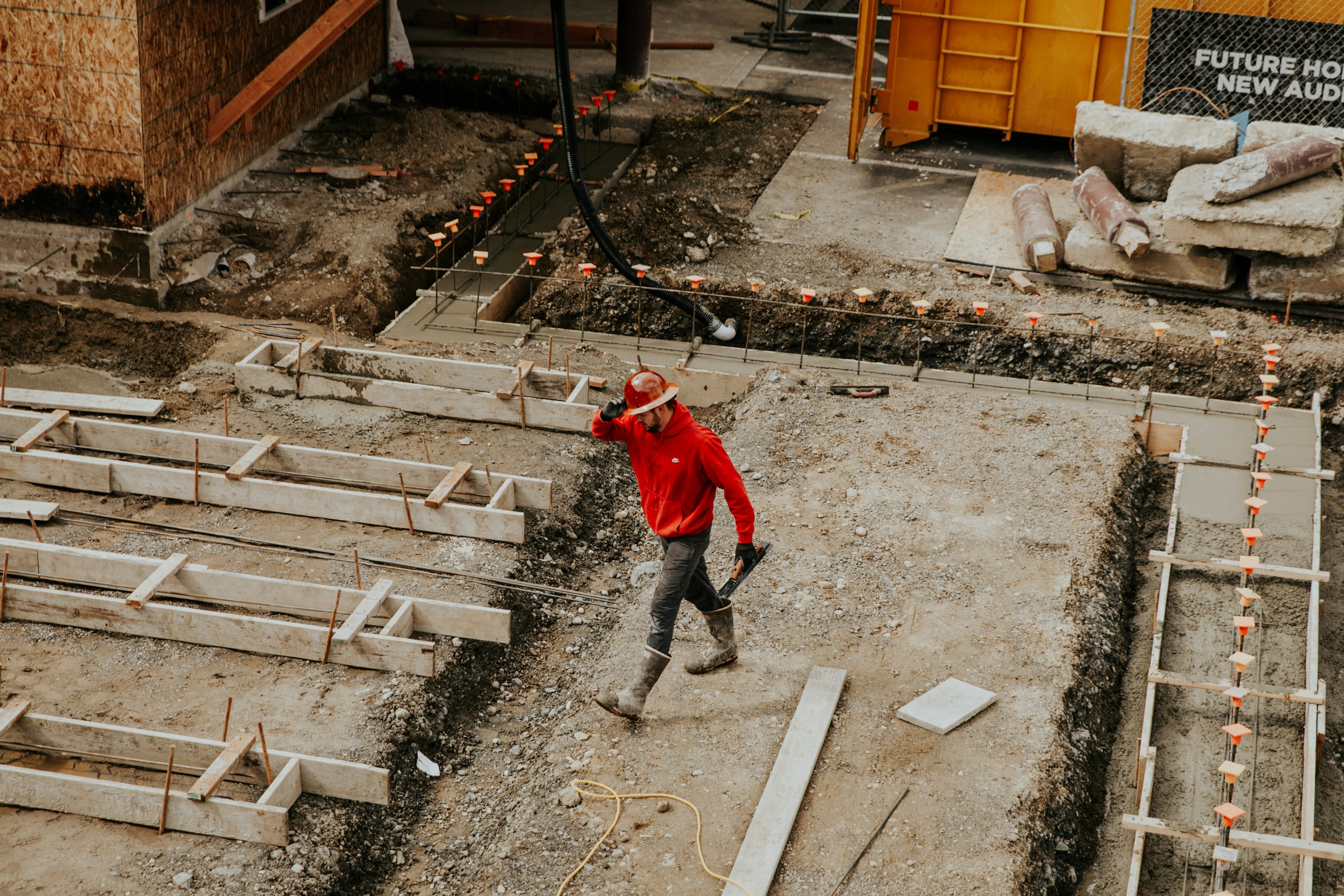 overhead view of an on-site construction worker in a red hoodie